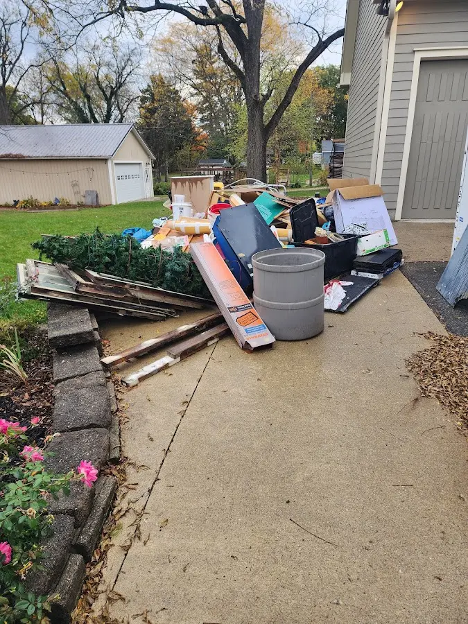 Dumpster being loaded with debris for Estate Cleanout Dumpster Rental in Mehlville